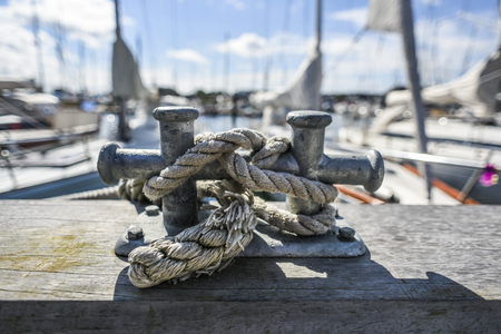 Old  harbor mooring in the background of the summer marina on a sunny day.の写真素材