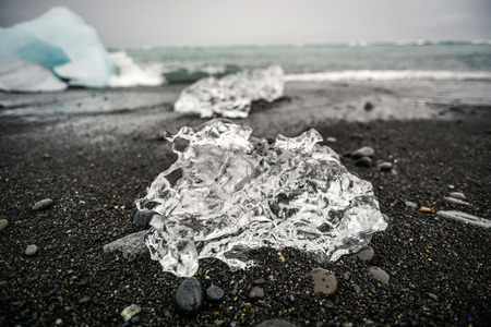 Ice sheet lying on a black beach in Iceland, ocean coast near Jökulsárlón - Glacier Lagoon.の写真素材