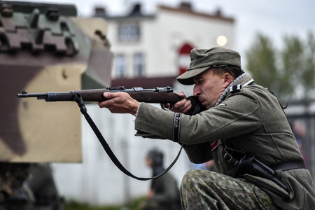 Gryfino, Poland, 23 september 2017: Historical reconstruction of the battle at Arnhem, a German soldier aiming with a rifle.のeditorial素材