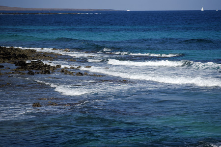 Volcanic rocks protruding from the assessment at the coast of the island of Lanzaroteの写真素材