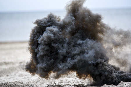 Explosion on the beach, billowing black smoke.