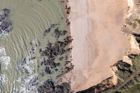 Water texture, rocks, sandy beach, ocean landscape.