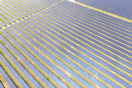 Photovoltaic farm. Photovoltaic panels in a field, view from a drone.