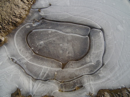 Ice cover. Frozen puddle. Air bubbles under the ice. winterの写真素材