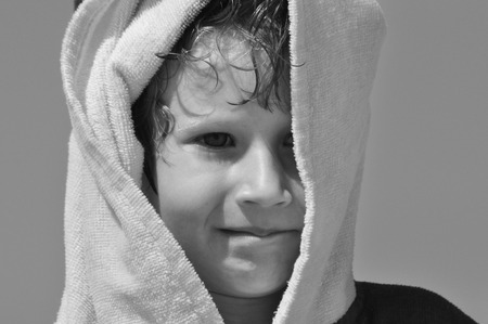 The boy, a child in a towel and hood on the beachの写真素材