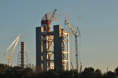 Power plant. Crane at a construction site. Chimney and smoke