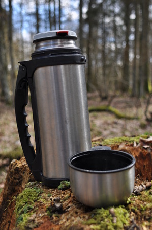 Hot tea in thermos for a walk in the woods while restingの写真素材