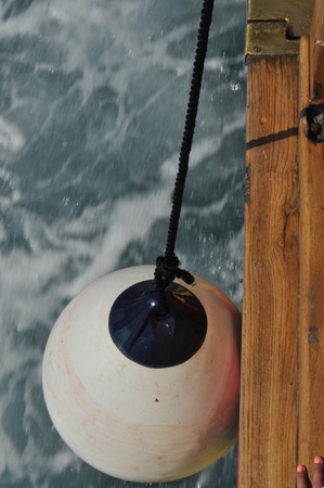 The crumpling dangling on the rope, on the wharf of the ship during the mooring.の写真素材
