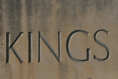 The word Kings is carved into a weathered stone surface, showing intricate lettering that highlights the craftsmanship. The texture emphasizes age.の写真素材