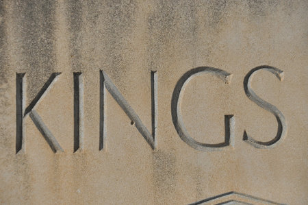 Bold letters spell out Kings on a weathered stone wall. The inscription features deep carvings with a rough texture, showing its age and historical significance.の写真素材