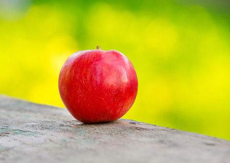 Fresh red apple on green background with bokehの写真素材