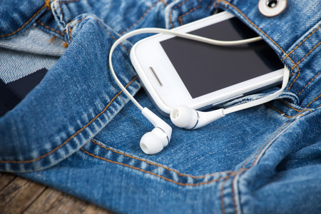 headphones and smartphone in the pocket old denim jacketの写真素材