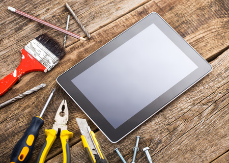 Different equipment tools of builder and tablet pc on wooden texture tableの写真素材