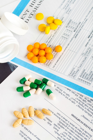 Doctor workplace. Different groups of pills, tablets, capsules on patient history databaseの写真素材