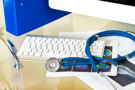 Doctor workplace. stethoscope on patient history database and x-ray