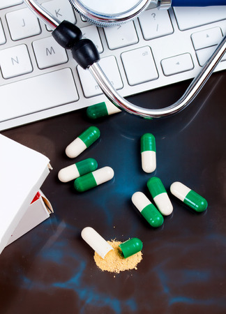 close-up green, white open medical capsules, (one opened), on black backgroundの写真素材