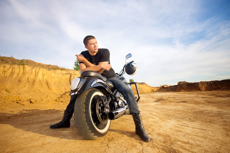 Smiling happy biker in sitting unknown on big chopper bike on roadの写真素材