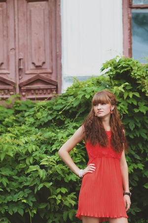 Closeup portrait of a beautiful girl in a red dressの写真素材