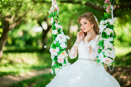 Young Happy Bride With Flower Bouquet on swingの写真素材