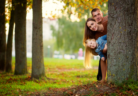 Portrait of happy family standing by a treeの写真素材