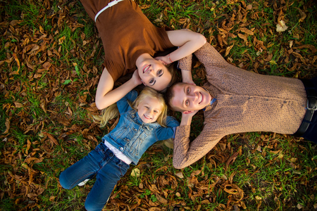 Happy mother, father and daughter in the parkの写真素材