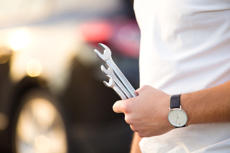 Man with wrench in hands repair car on roadの写真素材