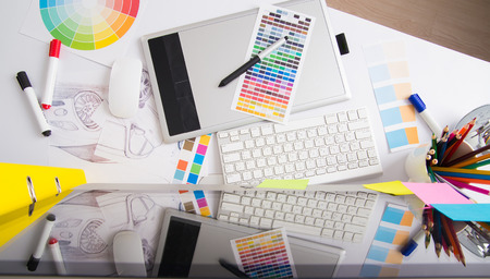 Modern office workplace with digital tablet, notepad, colorful pencils, glasses, in morningの写真素材