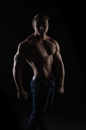 naked torso male bodybuilder athlete in the studio on a black backgroundの写真素材