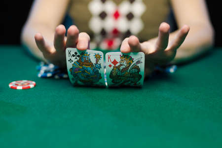 Female hands lay out playing cards and chips in a casino on a green table
