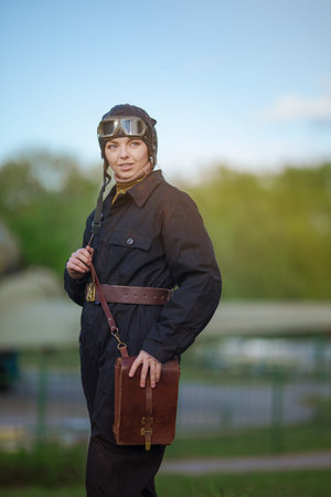 A young female pilot in uniform of Soviet Army pilots during the World War II. Black flying...