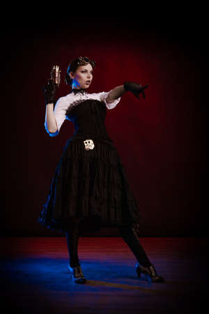 Emotional woman in steampunk costume posing in blue and red stage lightの写真素材