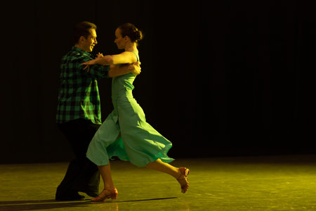 A pair of dancers a man and a woman perform in a theater on stage in a dance musical show.