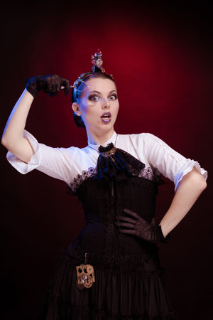 Emotional woman in steampunk costume posing in blue and red stage light
