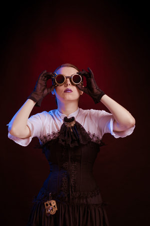 Emotional woman in steampunk costume posing in blue and red stage light