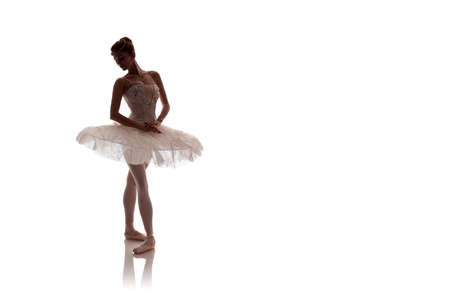 woman ballerina in white pack posing on white background photo made in the style of "low key"の写真素材