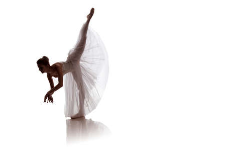 woman ballerina in white long skirt posing on white background photo made in the style of "low key"の写真素材