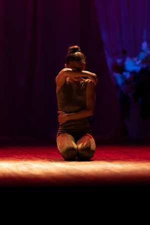 Young girl gymnast performs with a performance on stage in a theaterの写真素材