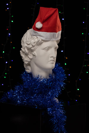 White Plaster Statue of Apollo Belvedere in a red cap of Santa Clausの写真素材