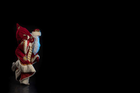 Santa Claus in a red suit and the Snow Maiden in a white fur coat posing against a black backgroundの写真素材