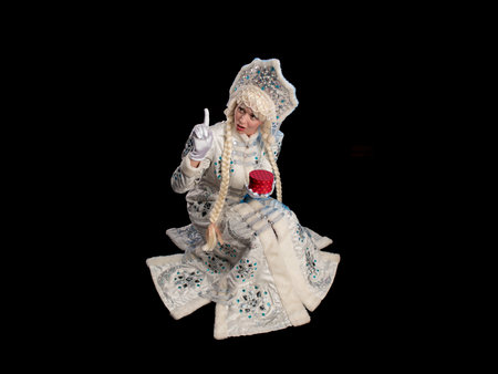 Snow Maiden in a white fur coat, kokoshnik and long hair braids posing on a black backgroundの写真素材