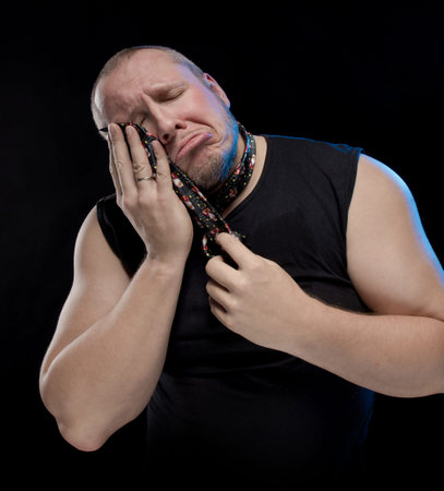 Emotional comic actor gesturing man in a tie on a black background, Christmas and New Year