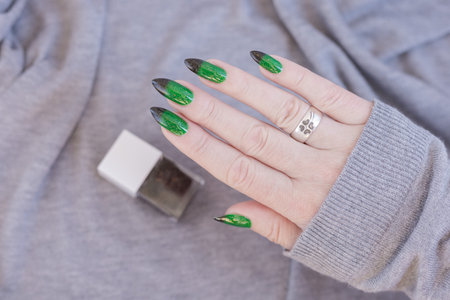Female hands with long nails with green nail polishの写真素材