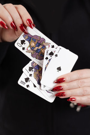 Female hands hold a deck of cards and show tricks. The photographer is the author of the design of...