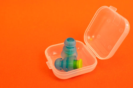 Silicone ear plugs for human ears on red backgroundの写真素材