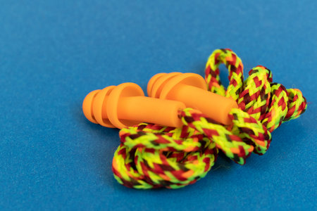 Silicone ear plugs for human ears on blue background