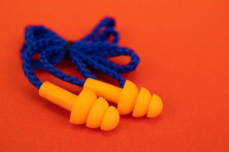Silicone ear plugs for human ears on red backgroundの写真素材