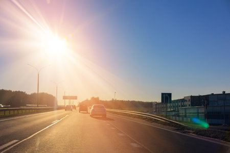 Autumn landscape and view of the road. Orange evening sun and reflections on road.の写真素材