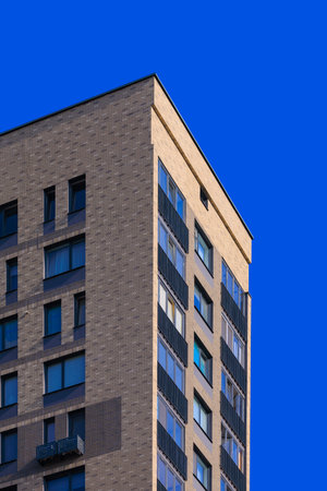 Cityscape on a summer day, modern buildings and houses against the blue sky