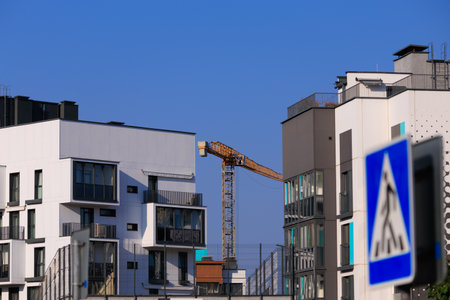 City view on a sunny day. Modern building and houses against the blue sky.の写真素材