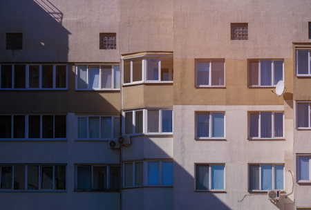 City view on a sunny day. Modern building and houses against the blue sky.の写真素材